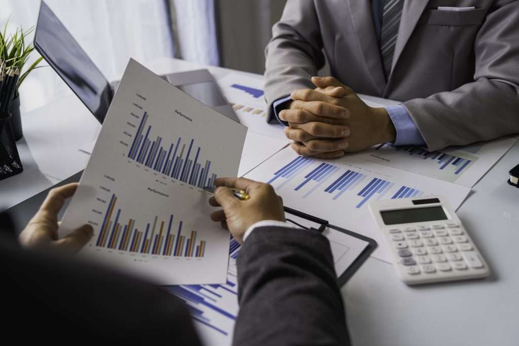 Peace of Mind Business Solutions professionals analyzing financial statements with charts and graphs during a business meeting.